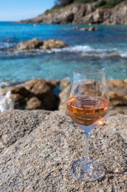 Provence 'de yaz zamanı, kumlu sahilde bir bardak soğuk gül şarabı ve güneşli bir günde Saint-Tropez yakınlarında mavi deniz suyu, Var Bölümü, Fransa