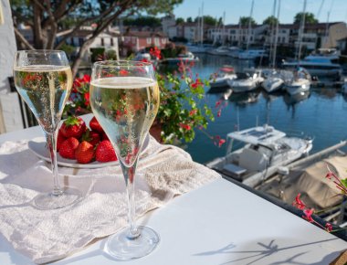 Yaz partisi, Fransız brut şampanyası bardaklara köpüklü şarap dökülmesi Saint-Tropez yakınlarındaki Port Grimaud limanında, Fransız Riviera tatili, Fransa