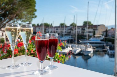 Kir Royal kokteyli ile yaz partisi, Fransız brut şampanyası tadı köpüklü şarap ve soğuk kremalı cassis Saint-Tropez yakınlarındaki Port Grimaud limanında, Fransız Riviera tatili, Fransa