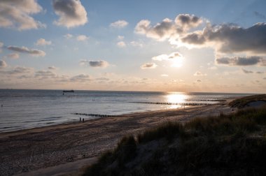 Beyaz kumlu sahildeki panoramik manzara, Kuzey Denizi 'nin Vlissingen en Domburg, Zeeland, Hollanda arasındaki kum tepeleri ve suyu