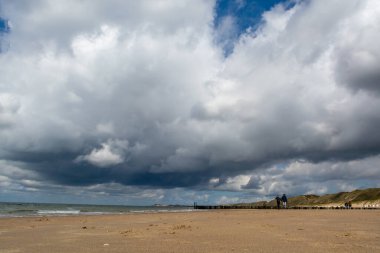 Zoutelande, Zeeland, Hollanda yakınlarındaki beyaz kumlu deniz sahillerinde alçak gelgit ve fırtına sırasında yürüyorum