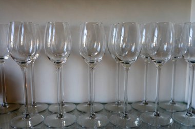 Restorandaki raflarda bir sürü boş temiz şarap ve tatlı şarabı kadehi var.