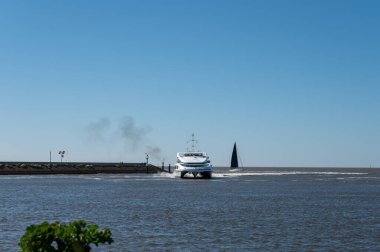 Hollanda, Friesland, Wadden Denizi 'ndeki Harlingen balıkçı kasabasının sahilinde yürüyorum.
