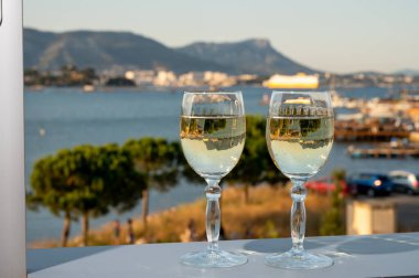 Fransız Rivierası 'nda yaz mevsimi, Cotes de Provence' den soğuk beyaz şarap içmek açık teraslarda Toulon, Var, Fransa limanı manzaralı.