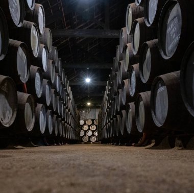 Portekiz 'in kuzeyindeki Vila Nova de Gaia' da güçlendirilmiş yakut ya da tawny porto şarabının yavaş yaşlanması için meşe ağacı fıçılarıyla dolu eski bir porto kulübesi.