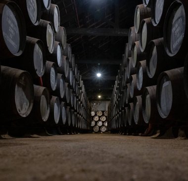 Portekiz 'in kuzeyindeki Vila Nova de Gaia' da güçlendirilmiş yakut ya da tawny porto şarabının yavaş yaşlanması için meşe ağacı fıçılarıyla dolu eski bir porto kulübesi.