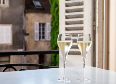 Romantik bir parti, iki bardak soğuk şampanya köpüklü köpüklü köpüklü şarap ve Fransız köyündeki eski cadde manzaralı.