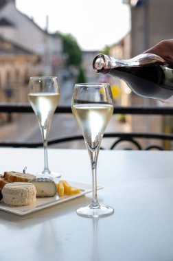 Romantik bir parti, iki bardak soğuk şampanya köpüklü köpüklü köpüklü şarap ve Fransız köyündeki eski cadde manzaralı.