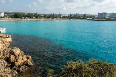 Kıbrıs Rum Kesimi 'nin Ayia Napa kentindeki beyaz kumlu Nissi plajında Akdeniz' in berrak mavi suyu