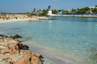 Kıbrıs Rum Kesimi 'nin Ayia Napa kentindeki beyaz kumlu Nissi plajında Akdeniz' in berrak mavi suyu