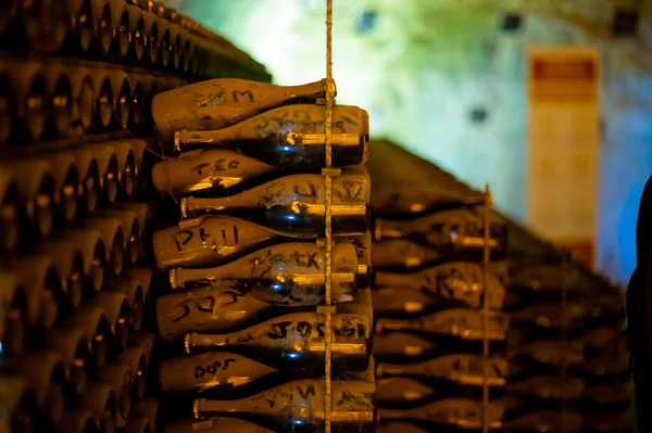 地下深く長い洞窟のラックの上にほこりっぽいボトル シャルドネからシャンパンスパークリングワインとランスのピノ ノワールのブドウを作る シャンパン フランス — ストック写真