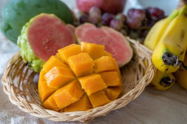 Kıbrıs 'ın egzotik meyveleri, taze sarı sulu mango, olgun pembe guava, muz ve yemeye hazır tatlı üzümler.