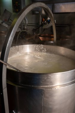 İtalya 'nın Parma kentindeki küçük peynir çiftliğinde sabahın erken saatlerinde taze, yumuşak ricotta peyniri yapma süreci.