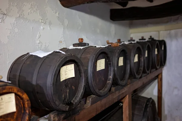 Traditional production and aging in wooden barrels of black Italian Balsamic wine IGP and DOC vinegar dressing in Modena, Italy