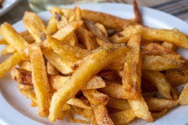 Lezzetli Kıbrıs Rum kızarmış patates çubukları, karabiber ve tuz yakın plan.