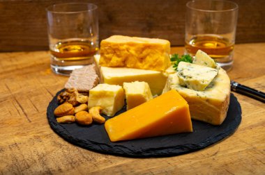 İngiliz içecekleri ve yiyecek eşleşmesi, bir bardak viski ve peynir koleksiyonu, mavi Stilton, İskoç renkli ve İngiliz olgun çedar peyniri