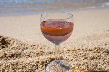 Beyaz kumlu sahilde yerel gül şarabı ve arka planda mavi Akdeniz, Le Lavandou, Var, Provence, Fransa yakınlarında