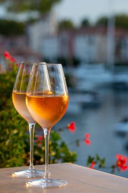 Yaz günbatımında yerel soğuk gül şarabının tadına bakmak arka planda liman, Provence, Var, Fransa