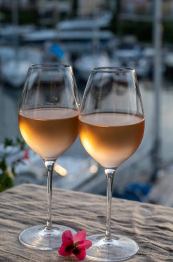 Yaz günbatımında yerel soğuk gül şarabının tadına bakmak arka planda liman, Provence, Var, Fransa