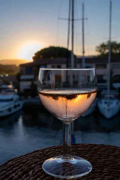 Yazın günbatımında yerel soğuk gül şarabı içmek arka planda liman, Provence, Var, Fransa