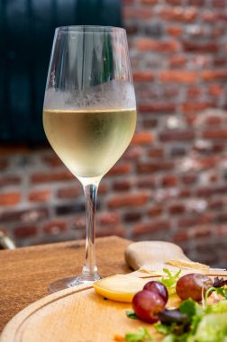 Belçika 'nın eski kafesindeki terasta servis edilen bir bardak soğuk beyaz şarap.