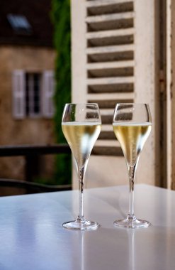 Romantik bir parti, iki bardak soğuk şampanya köpüklü köpüklü köpüklü şarap ve Fransız köyündeki eski cadde manzaralı.