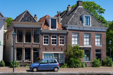 Güneşli bir günde Hollanda, Friesland, Wadden Denizi 'ndeki Harlingen balıkçı kasabasının eski sokaklarında yürüyorum.