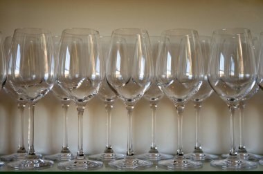 Restorandaki raflarda bir sürü boş temiz şarap ve tatlı şarabı kadehi var.