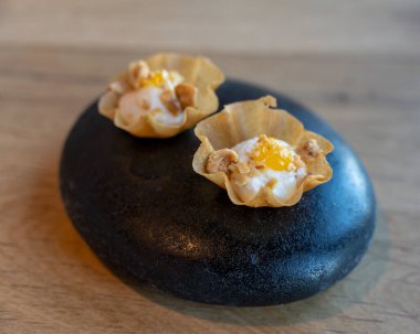 Modern restoranda siyah taşta servis edilen lezzetli vejetaryen aperatifleri.