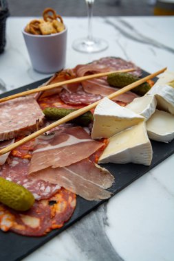 Siyah taş tahtada servis edilen et ve peynir çeşitleri