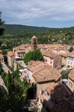 Fransa 'nın Provence kentindeki Moustiers-Sainte-Marie kasabasındaki dağlık uçurum, eski evler, yeşil vadi. Turistik bir yer.