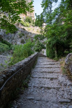 Fransa 'nın Provence kentindeki Moustiers-Sainte-Marie kasabasındaki dağlık uçurum, eski evler, yeşil vadi. Turistik bir yer.