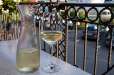 Beyaz kaliteli şarap tatma Mosel şarap bölgesinde açık terasta servis edilir ve güneşli bir günde arka planda eski Alman kasabası, Almanya