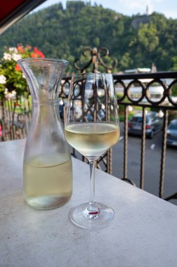 Beyaz kaliteli şarap tatma Mosel şarap bölgesinde açık terasta servis edilir ve güneşli bir günde arka planda eski Alman kasabası, Almanya