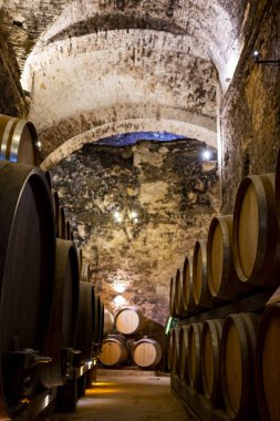 İtalya 'nın Toskana kentindeki Montepulciano Tepesi' nde şarap nobile di Montepulciano 'nun yaşlanması için eski kırmızı şarap fıçılarıyla ortaçağ yeraltı şarap mahzenleri.
