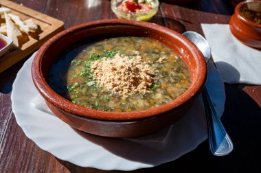 Tenerife 'deki tipik bir Kanarya Adası işletmesi olan Guachinche' de akşam yemeği, yerel olarak üretilen beyaz veya kırmızı şarap ile birlikte güneşli bir günde ev yapımı geleneksel yemekler sunuluyor, gofio ile sebze çorbası.