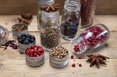 Küçük şişelerdeki profesyonel cin baharatları, pembe biber, amber çiçekleri, ardıç meyveleri, kakule, kişniş tohumları, yıldız anason yakın çekim