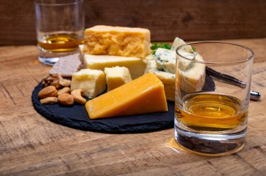 İngiliz içecekleri ve yiyecek eşleşmesi, bir bardak viski ve peynir koleksiyonu, mavi Stilton, İskoç renkli ve İngiliz olgun çedar peyniri