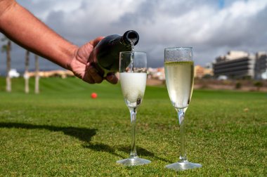 Şampiyonluğu kutlamak için şampanya kadehleri ile Tenerife, Kanarya Adaları 'ndaki golf kulübünün yeşil çimlerinde şarap