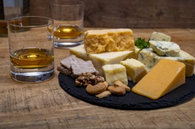 İngiliz içecekleri ve yiyecek eşleşmesi, bir bardak viski ve peynir koleksiyonu, mavi Stilton, İskoç renkli ve İngiliz olgun çedar peyniri