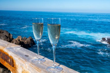 Yeni yıl kutlamalarında iki kadeh şampanya ya da İspanyol kavası köpüklü şarap ve Atlantik 'in mavi suları, Kanarya adaları, kış turistleri