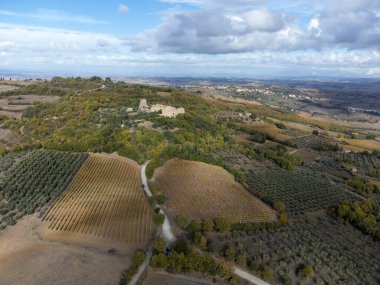Bagno Vignoni, Toskana, İtalya yakınlarındaki Val d 'Orcia tepelerinde hava panoramik manzarası. Selvi ağaçları, üzüm bağları, ormanlar ve bulutlu sonbaharda sürülen tarlalarla Toskana manzarası.