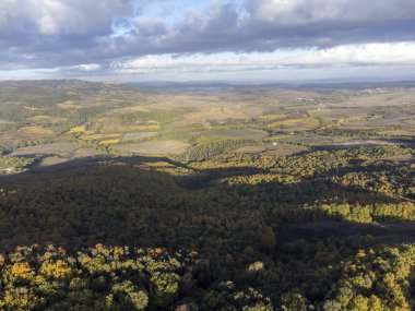 Val d 'Orcia tepelerinde Bagno Vignoni, Toskana, İtalya yakınlarında. Selvi ağaçları, üzüm bağları, ormanlar ve bulutlu sonbaharda sürülen tarlalarla Toskana manzarası.