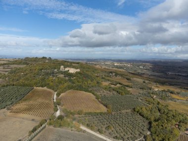 Bagno Vignoni, Toskana, İtalya yakınlarındaki Val d 'Orcia tepelerinde hava panoramik manzarası. Selvi ağaçları, üzüm bağları, ormanlar ve bulutlu sonbaharda sürülen tarlalarla Toskana manzarası.