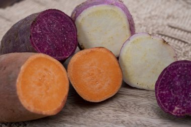 Renkli kök sebzeler pembe, mor ve turuncu organik tatlı patatesler yakın çekim