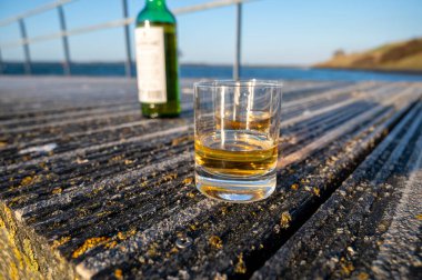 Gün batımında İskoç viskisi içmek deniz, okyanus veya nehir manzaralı, İskoçya, İngiltere 'de özel viski imalathanesi turları