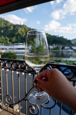 Mosel şarap bölgesinde açık havada servis edilen beyaz kaliteli şarap kadehiyle el ele tutuştuk. Mosel nehri ve eski Alman kasabası güneşli bir günde, Almanya 'da arka planda yer aldı.
