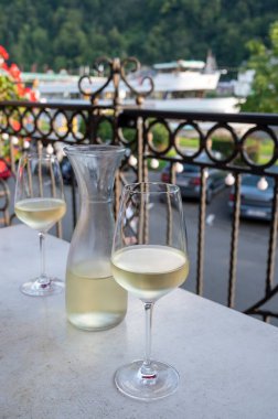 Beyaz kaliteli şarap tatma Mosel şarap bölgesinde açık terasta servis edilir ve güneşli bir günde arka planda eski Alman kasabası, Almanya