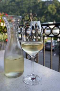Beyaz kaliteli şarap tatma Mosel şarap bölgesinde açık terasta servis edilir ve güneşli bir günde arka planda eski Alman kasabası, Almanya