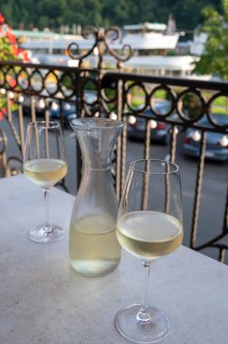 Beyaz kaliteli şarap tatma Mosel şarap bölgesinde açık terasta servis edilir ve güneşli bir günde arka planda eski Alman kasabası, Almanya